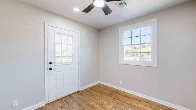 doorway with ceiling fan and light hardwood / wood-style flooring