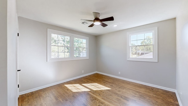 unfurnished room with plenty of natural light, ceiling fan, and wood-type flooring