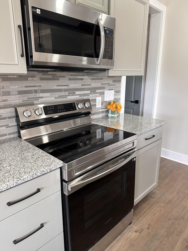292 Quebeck Rd, Quebeck, TN 38579 - kitchen featuring light wood-type flooring, light stone countertops, appliances with stainless steel finishes, and decorative backsplash