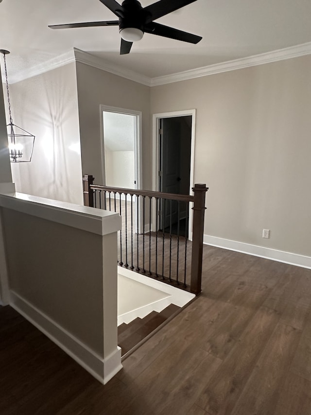 staircase featuring ornamental molding, ceiling fan with notable chandelier, and hardwood / wood-style floors