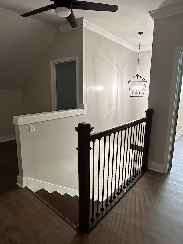 stairs featuring ceiling fan with notable chandelier, ornamental molding, and hardwood / wood-style flooring