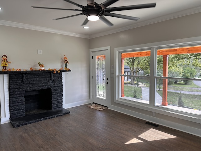 unfurnished living room featuring ornamental molding, dark hardwood / wood-style flooring, and a stone fireplace