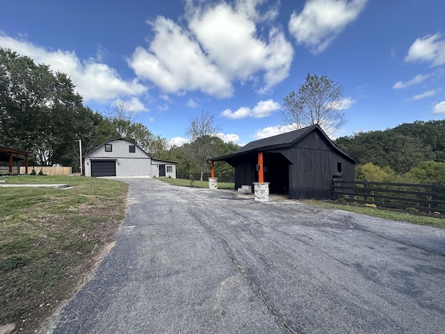 292 Quebeck Rd, Quebeck, TN 38579 - exterior space featuring an outdoor structure, aphalt driveway, a barn, fence, and a garage