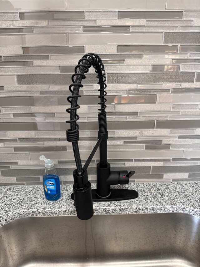 292 Quebeck Rd, Quebeck, TN 38579 - details with light stone countertops, a sink, and decorative backsplash