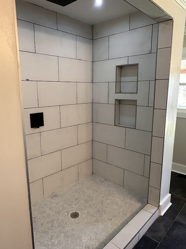 bathroom featuring a tile shower and tile patterned floors