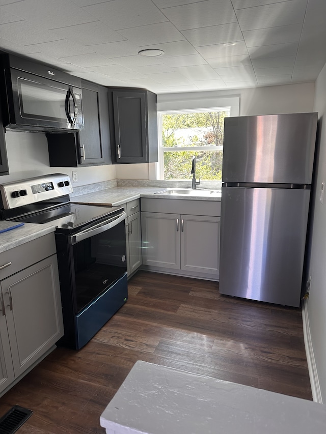 kitchen featuring gray cabinets, stainless steel appliances, sink, and dark hardwood / wood-style flooring