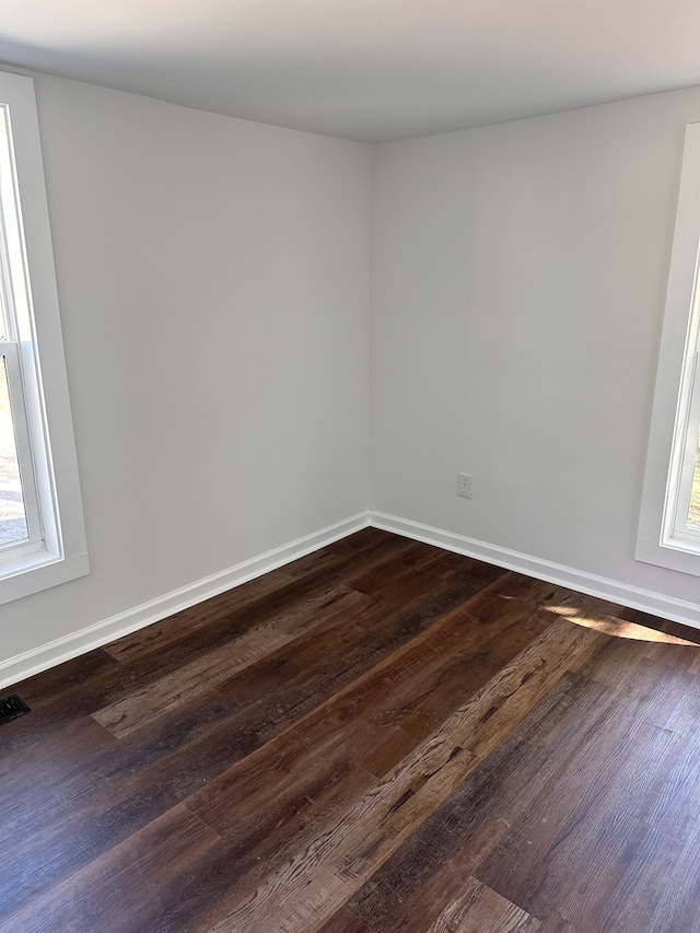 unfurnished room with dark wood-type flooring