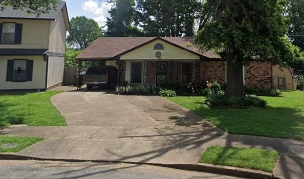 view of front of house with a carport and a front lawn