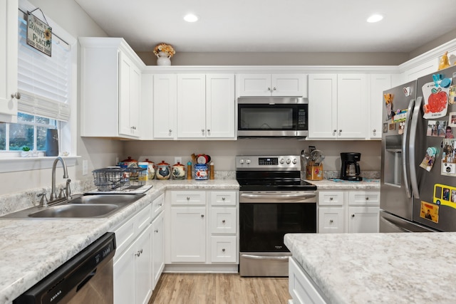 kitchen featuring white cabinetry, light hardwood / wood-style floors, appliances with stainless steel finishes, and sink