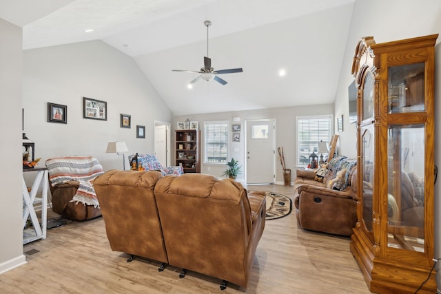 living room with light hardwood / wood-style flooring, ceiling fan, and high vaulted ceiling