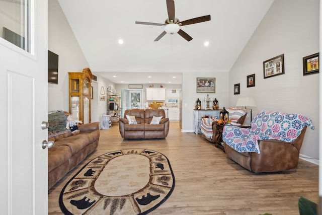 living room featuring light wood-type flooring, ceiling fan, and high vaulted ceiling