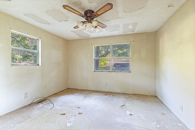 unfurnished room featuring ceiling fan and plenty of natural light