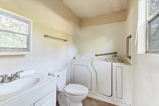 bathroom with plenty of natural light, vanity, and toilet