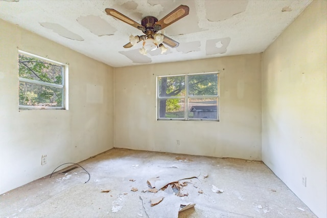 unfurnished room featuring a wealth of natural light and ceiling fan