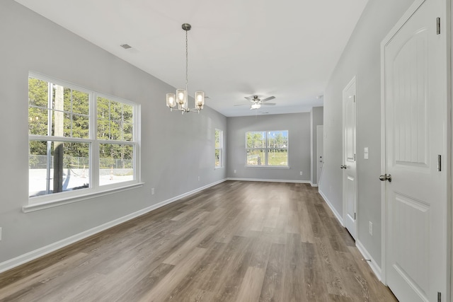 spare room featuring ceiling fan with notable chandelier and hardwood / wood-style flooring