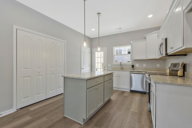 kitchen featuring light hardwood / wood-style flooring, a center island, appliances with stainless steel finishes, and white cabinetry