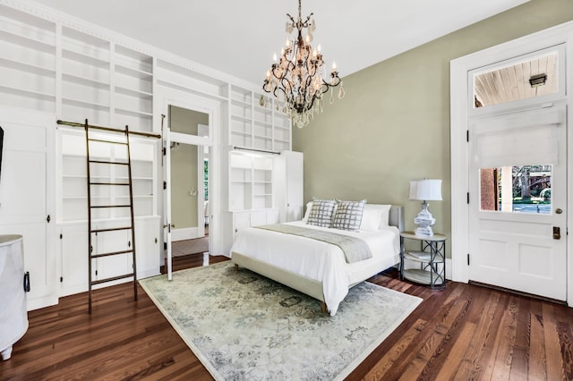 bedroom with an inviting chandelier, dark hardwood / wood-style floors, and a barn door