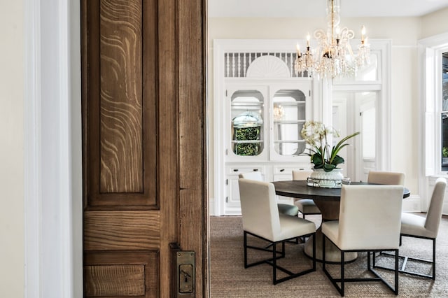 dining room with carpet flooring and a chandelier