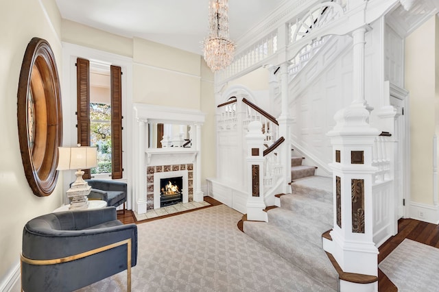 entrance foyer with hardwood / wood-style flooring, a towering ceiling, ornamental molding, and a chandelier