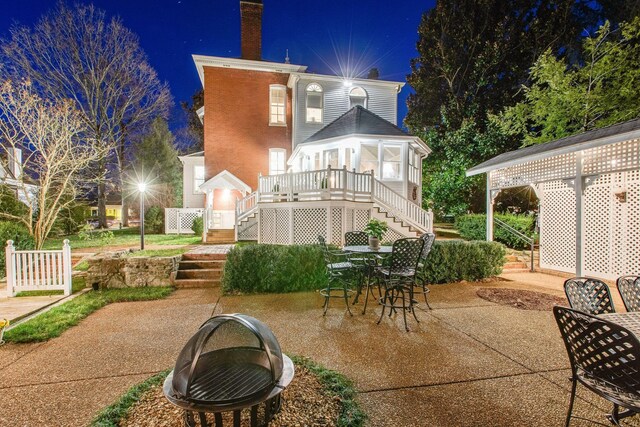 patio at night featuring a wooden deck