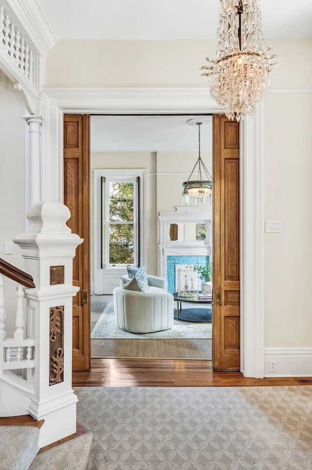 interior space with ornate columns, hardwood / wood-style floors, and ornamental molding