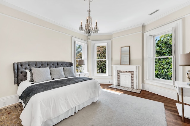 bedroom featuring wood-type flooring, ornamental molding, and a chandelier