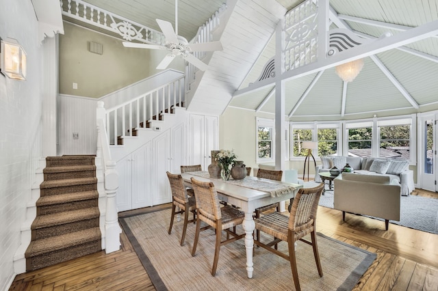 dining space featuring high vaulted ceiling, ceiling fan, beamed ceiling, hardwood / wood-style flooring, and wooden ceiling