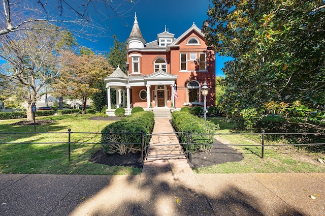 victorian home featuring a porch and a front lawn