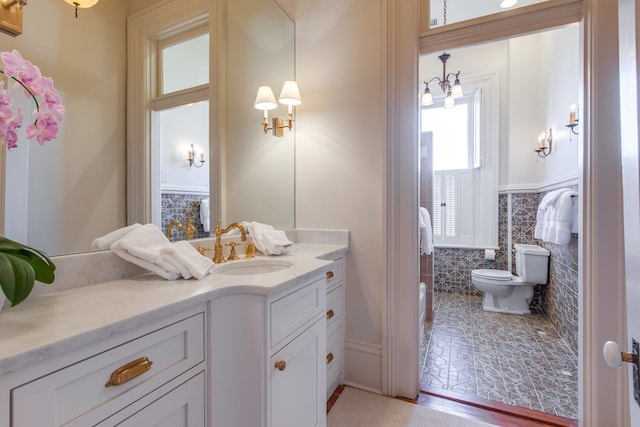 bathroom featuring wood-type flooring, tile walls, vanity, and toilet