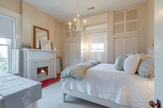 bedroom featuring carpet floors, an inviting chandelier, and multiple windows