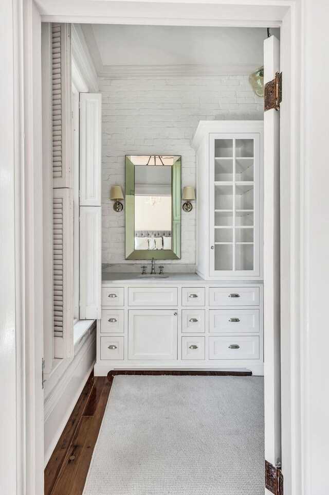 bathroom featuring ornamental molding, hardwood / wood-style flooring, and vanity