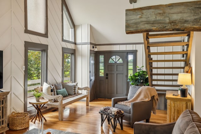 living area featuring light wood-type flooring and high vaulted ceiling