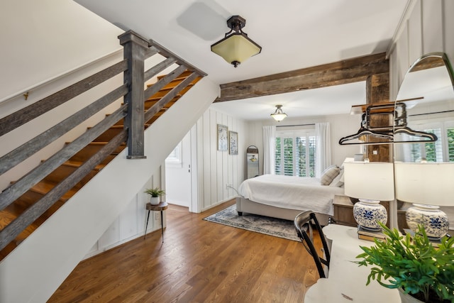 bedroom with beamed ceiling and dark hardwood / wood-style flooring