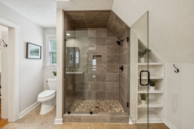 bathroom with a textured ceiling, walk in shower, tile patterned floors, and toilet