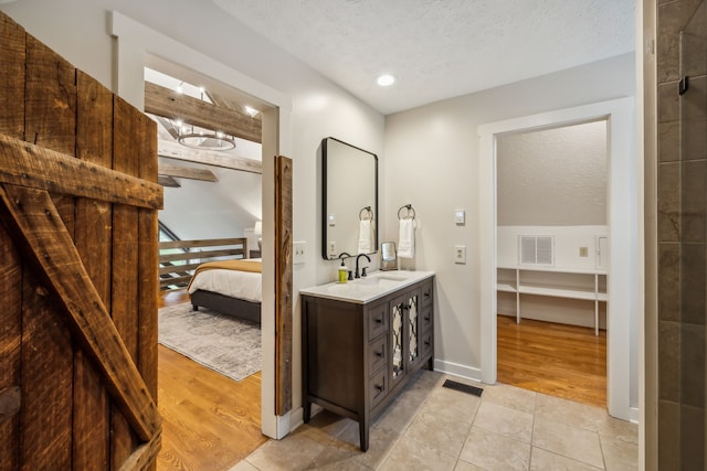 bathroom featuring vanity, hardwood / wood-style floors, and a textured ceiling