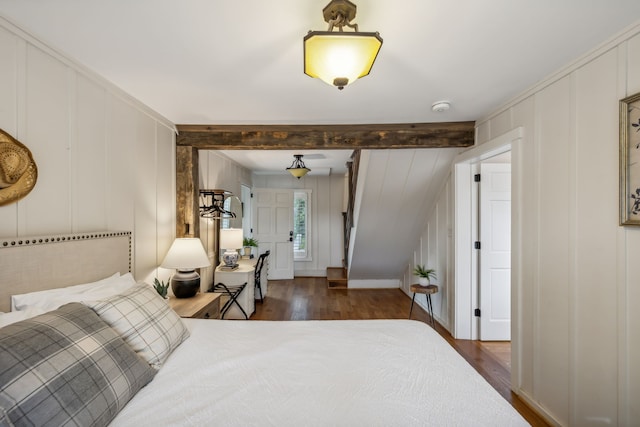 bedroom featuring dark hardwood / wood-style floors and beam ceiling