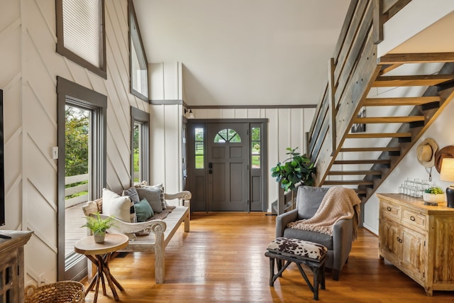 entryway with hardwood / wood-style flooring and a towering ceiling