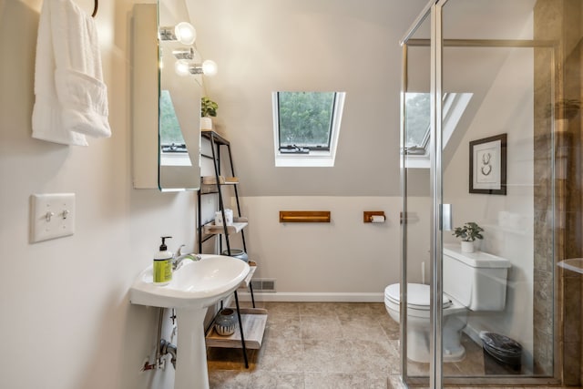 bathroom featuring a skylight, walk in shower, and toilet