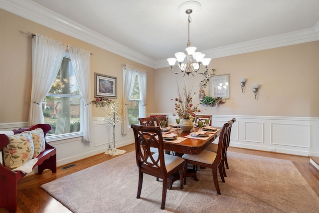 dining room featuring hardwood / wood-style floors, a chandelier, and ornamental molding