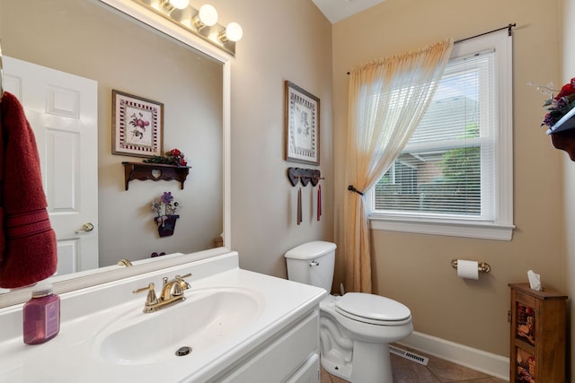 bathroom with vanity, tile patterned flooring, a healthy amount of sunlight, and toilet