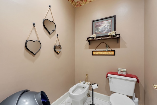 bathroom featuring toilet, a bidet, and tile patterned floors