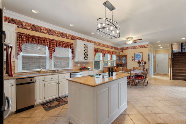 kitchen featuring black electric stovetop, ornamental molding, a kitchen island, white cabinetry, and decorative light fixtures