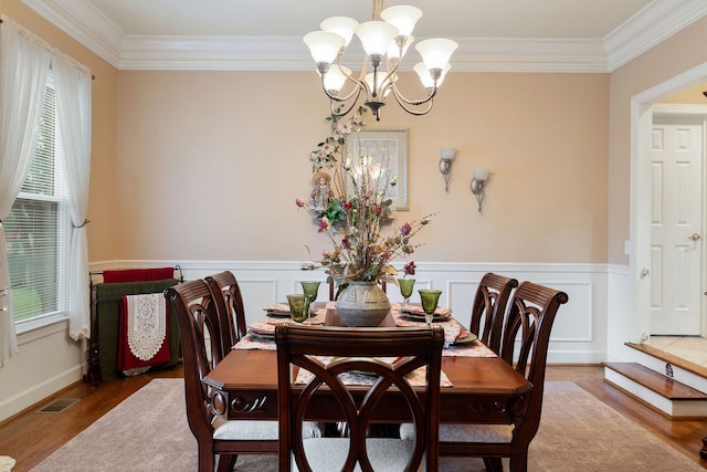 dining room with an inviting chandelier, wood-type flooring, and crown molding