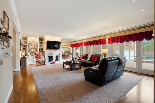 living room with wood-type flooring, built in features, and crown molding