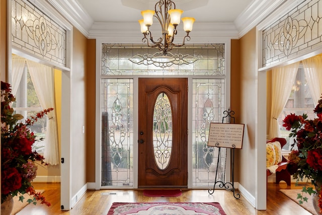 entryway featuring ornamental molding, a notable chandelier, and light hardwood / wood-style floors