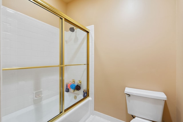 bathroom with toilet and bath / shower combo with glass door