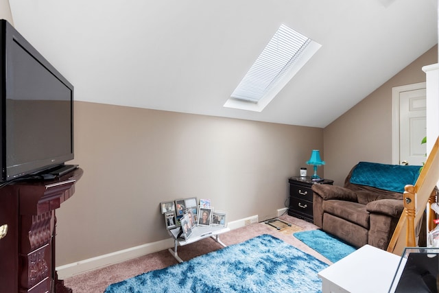 sitting room with vaulted ceiling with skylight and carpet flooring