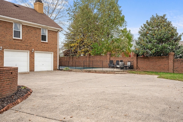 exterior space with a garage and a pool