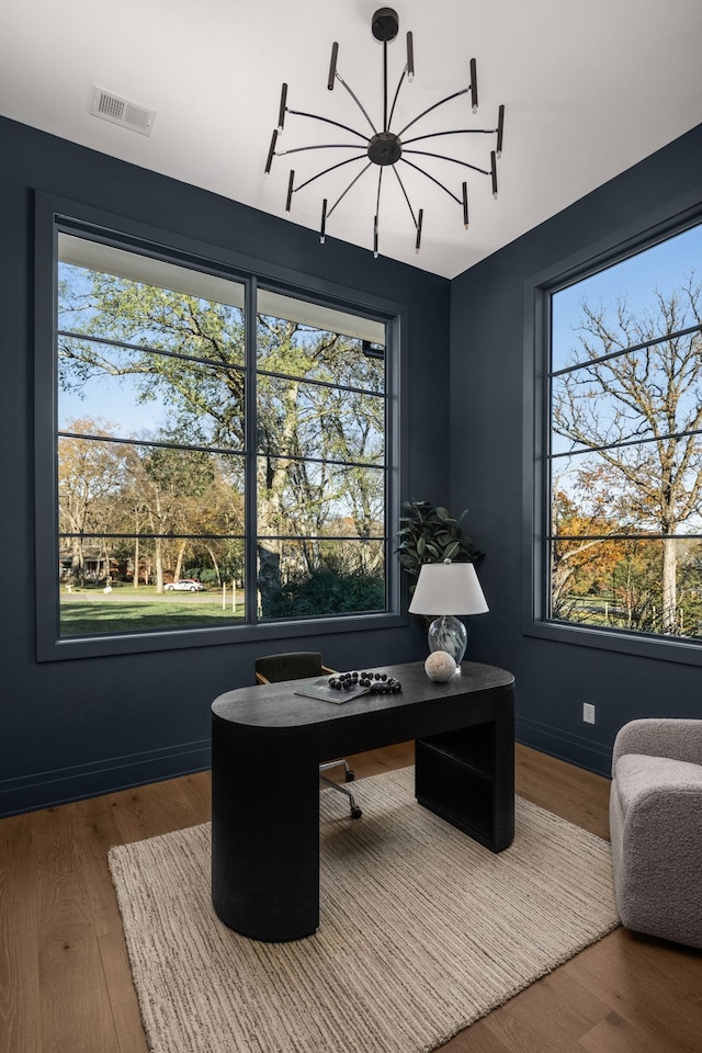 office space featuring hardwood / wood-style flooring, a wealth of natural light, and an inviting chandelier