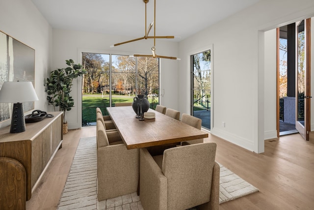 dining area featuring light hardwood / wood-style flooring and an inviting chandelier